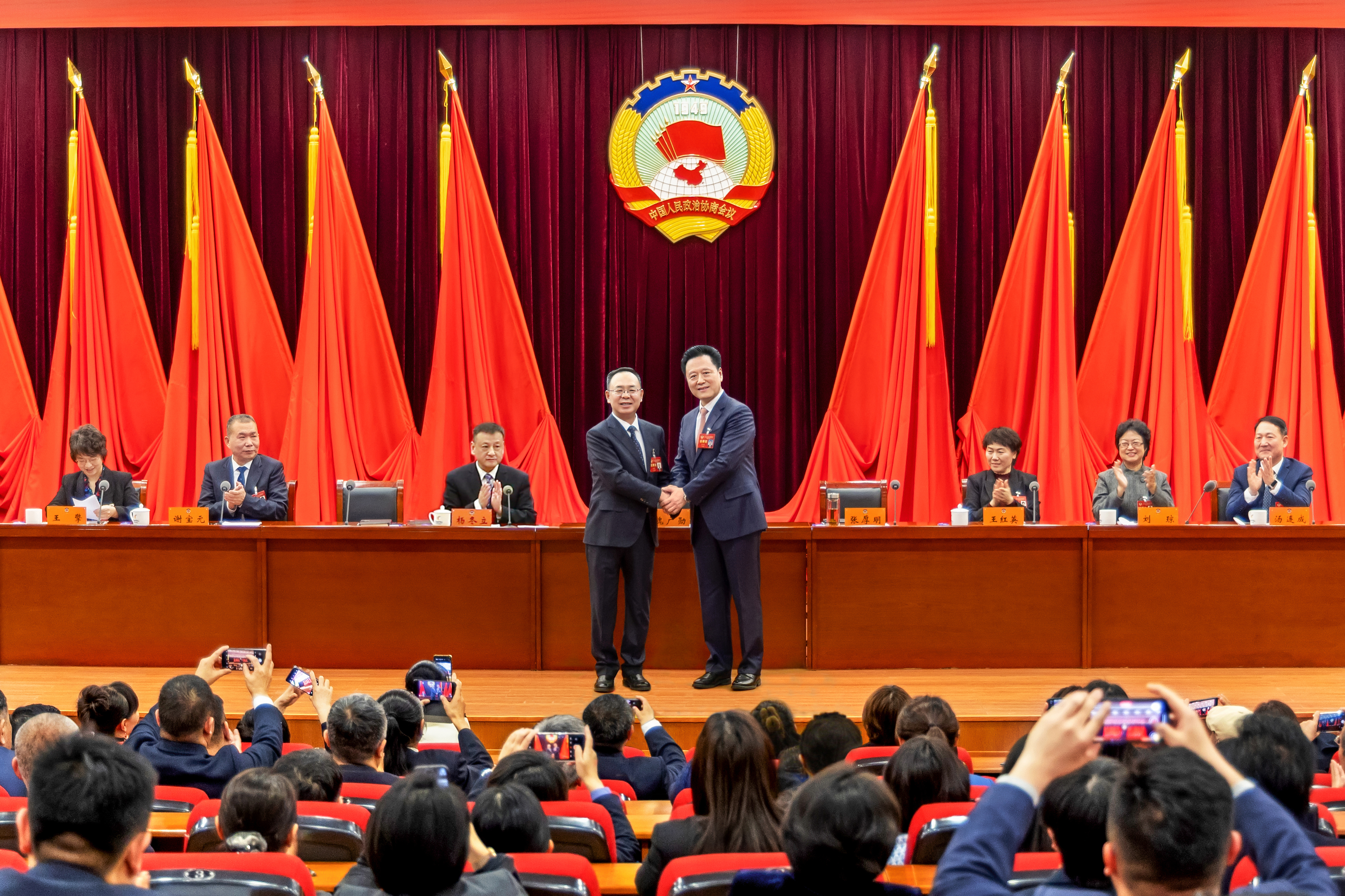 区政协九届五次会议上，新当选主席张厚明与原主席魏广勋握手.jpg